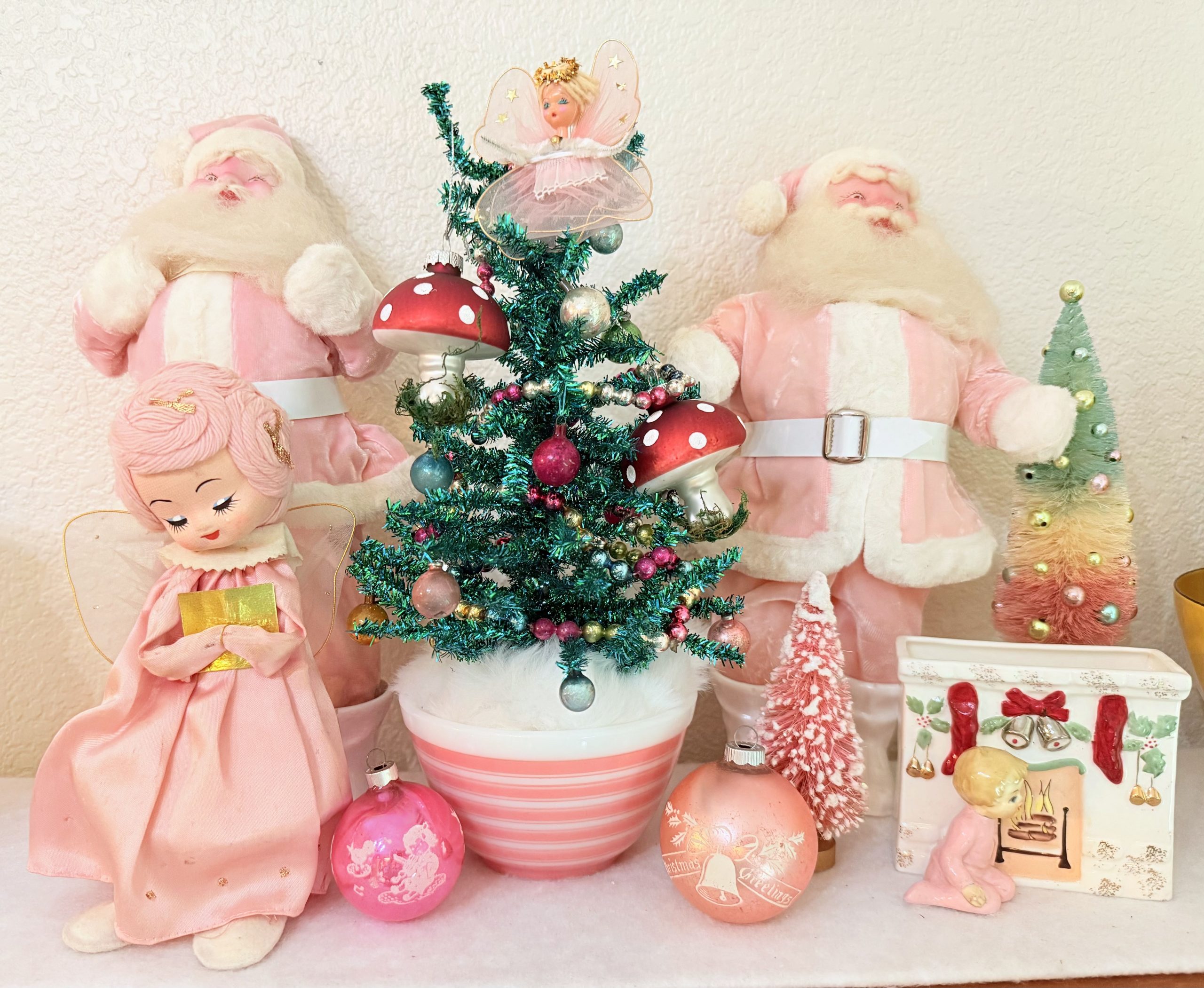 Vintage kitsch pink Christmas wonderland display with tinsel tree and pink Pyrex.